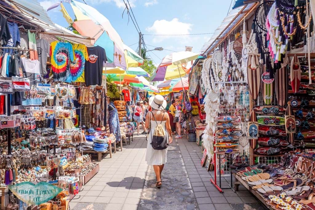 A vibrant traditional market offering handmade crafts, souvenirs, paintings, textiles, and local artworks.